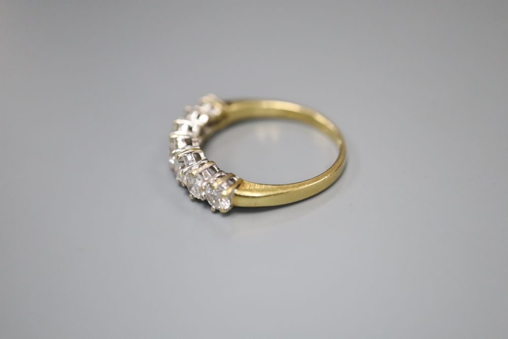 A modern 18ct gold and graduated seven stone diamond half hoop ring, size P, gross 3.6 grams.